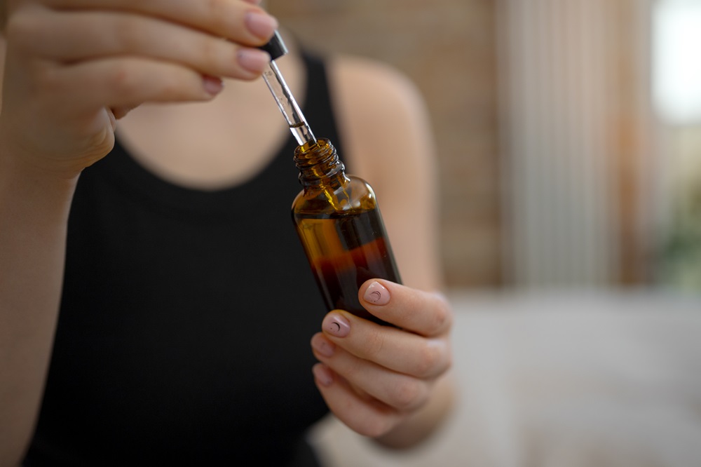 girl is applying natural oil on skin